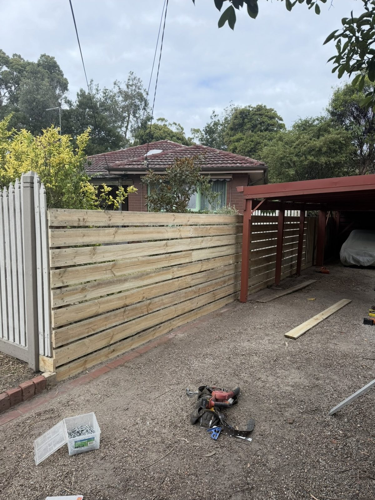 Low timber slat fence beside driveway