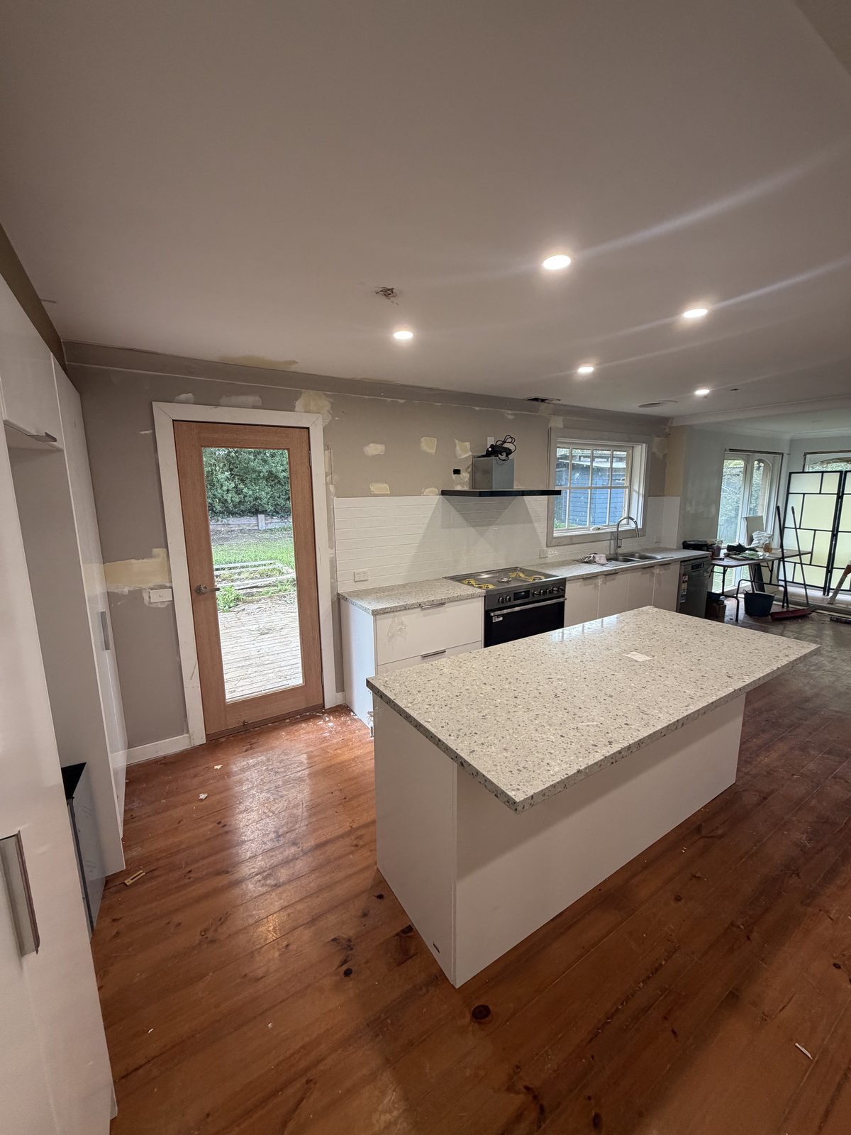 Kitchen renovation with stone island benchtop and white cabinetry