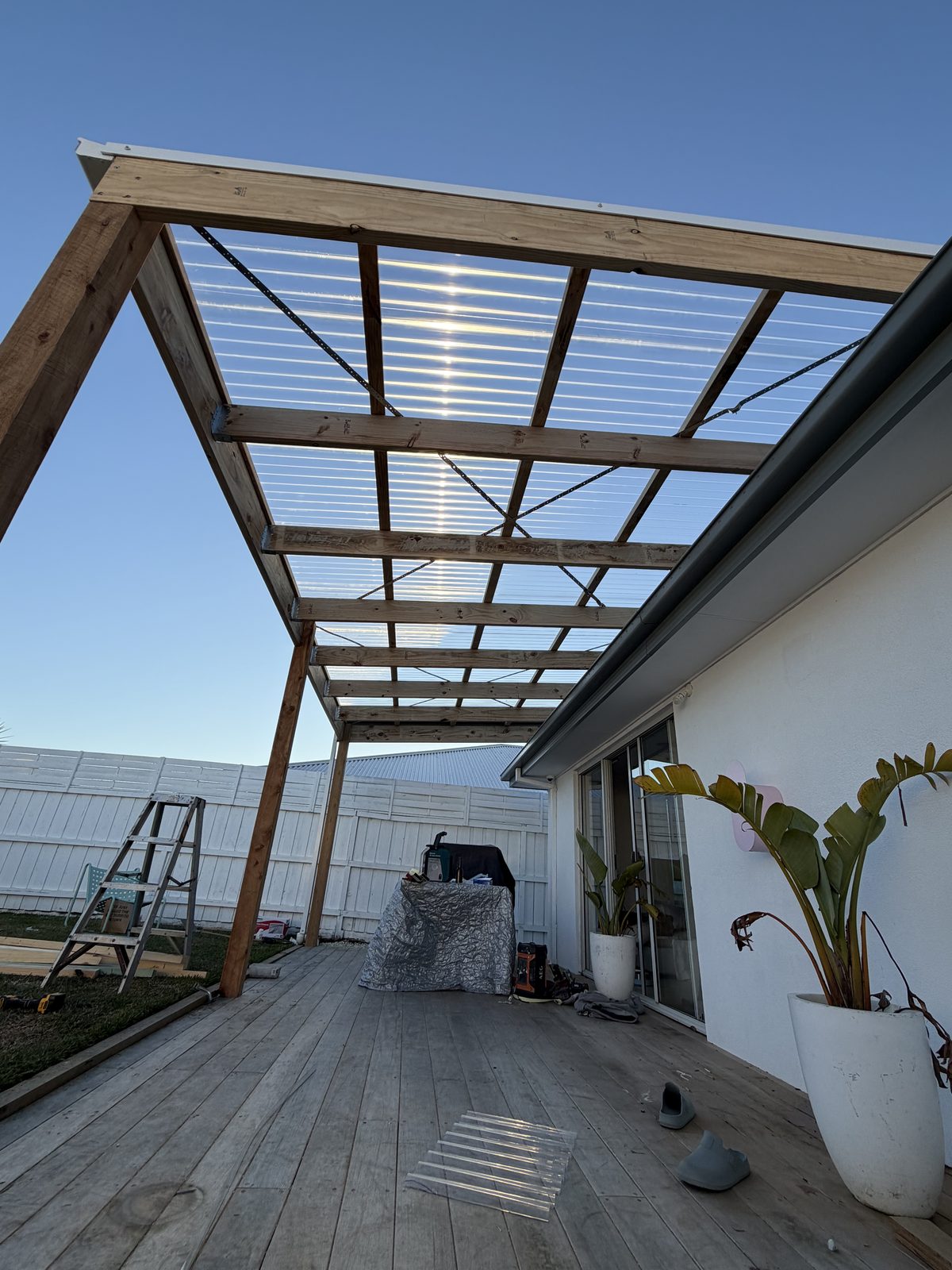 Polycarbonate patio roof frame under construction